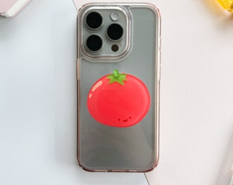 May include: A clear phone case with a red tomato design. The tomato has a green stem and a happy face.