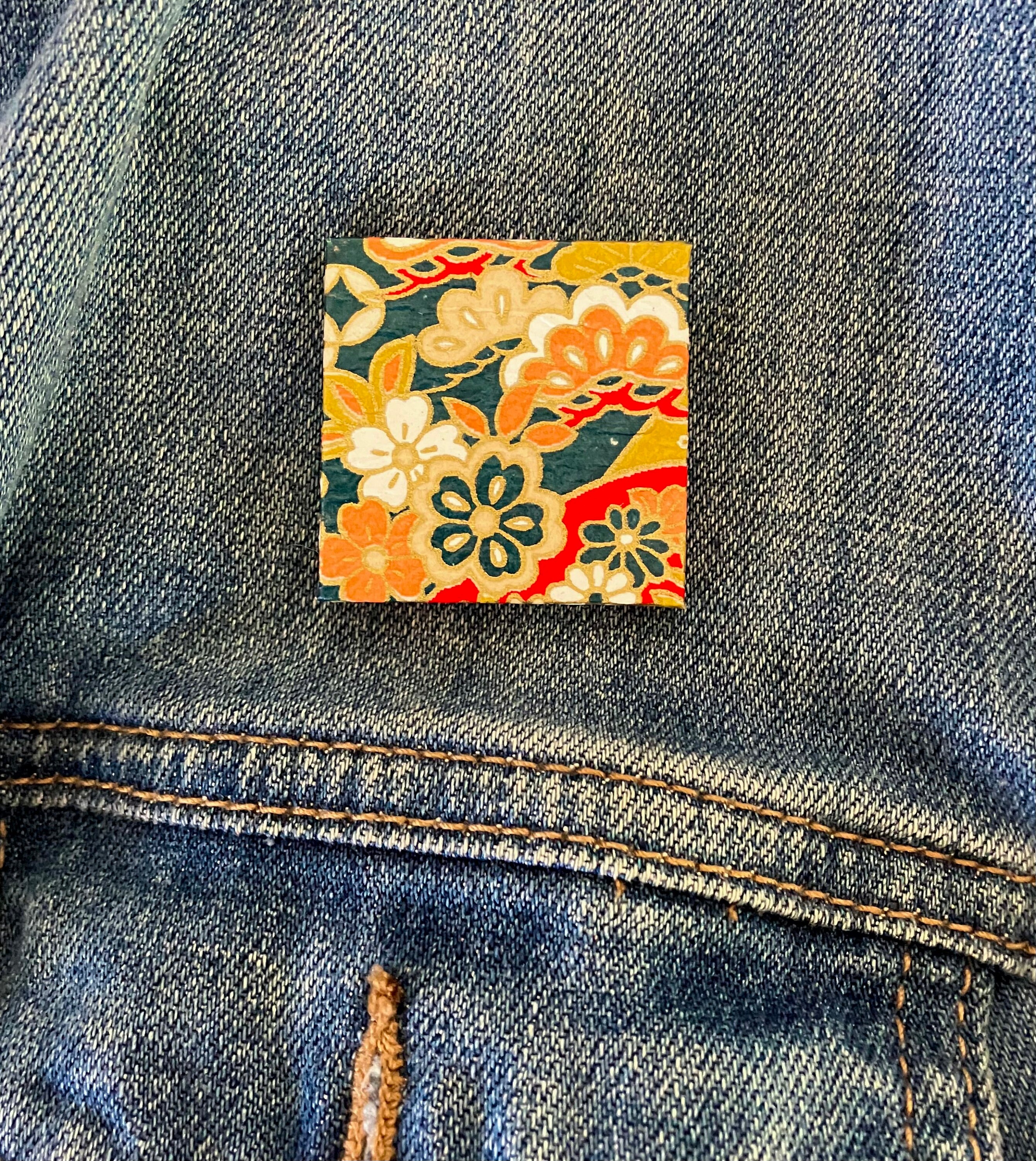 Unique Japanese Chiyogami washi pin brooch.  Handmade. Orange, white and gold flowers float on navy.  Free shipping and ready to ship now.