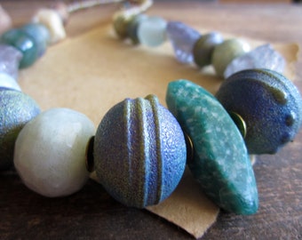 Chunky asymmetric necklace, Artisan lampwork glass beads African brass trade beads Aquamarine Amazonite Yellow opal Fluorite Green Purple
