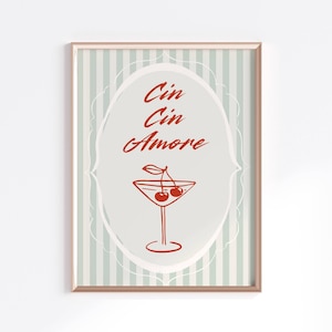 Puede incluir: Un estampado enmarcado con una ilustración de cóctel y cerezas. La obra de arte tiene un fondo a rayas azul claro y blanco. Las palabras "Cin Cin Amore" están escritas en cursiva en el centro del estampado.