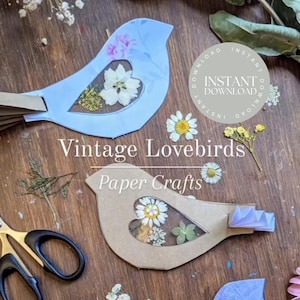 May include: A printable craft project featuring two lovebirds with heart-shaped windows. The birds are made of paper and can be decorated with pressed flowers. The text "Vintage Lovebirds Paper Crafts" and "Instant Download" is visible in the image.