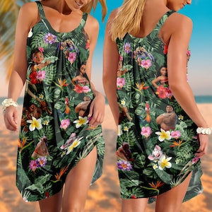 May include: Sleeveless dress with a tropical print featuring cartoon characters, flowers, and lush green foliage. The dress has a dark background and a flowing silhouette, perfect for warm weather.
