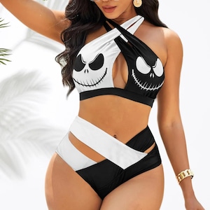 May include: A black and white two-piece swimsuit with a Jack Skellington face design on the halter top. The high-waisted bottoms have cut-out details. The swimsuit is designed for a comfortable fit. The measurements are in centimetres.