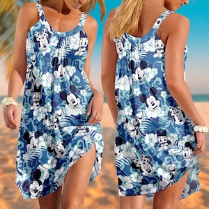 May include: A blue and white sleeveless dress with a pattern of Mickey Mouse, Minnie Mouse, and other Disney characters. The dress has a floral design and a side slit. The dress is made of a lightweight fabric.