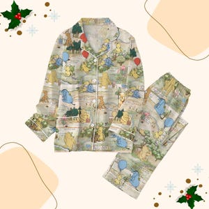 May include: A beige two-piece pyjama set with a Winnie the Pooh map design. The set includes a button-down top and matching trousers, both with white trim. The pyjamas are decorated with illustrations of Winnie the Pooh and friends.