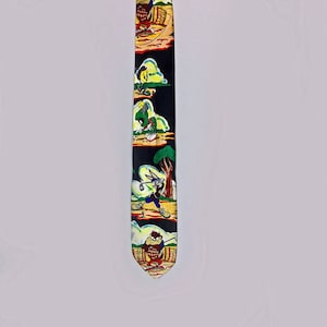 May include: A black necktie featuring cartoon characters in various golf-themed scenes. The tie has a repeating pattern of Bugs Bunny, Taz, and other characters on a black background with yellow, green, and brown accents.