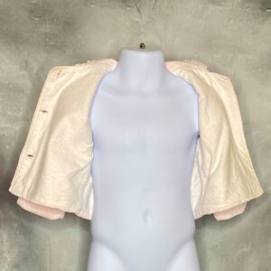 May include: A white fleece jacket with a pink trim. The jacket is open and the lining is visible.