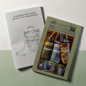 May include: Two instructional booklets titled Suzanne's Art House Water Bottle Sling Bag #229. One booklet features a black and white line drawing of a sling bag, while the other displays color photographs of various fabric water bottle carriers.