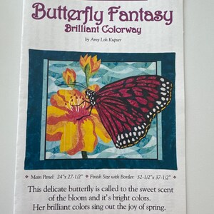 May include: A quilting pattern for a butterfly fantasy design. The pattern features a butterfly with pink and black wings landing on a yellow flower. The text on the pattern reads "Butterfly Fantasy Brilliant Colorway by Amy Loh Kupser". The pattern is 24 inches by 27.5 inches and the finished size with border is 32.5 inches by 37.5 inches.