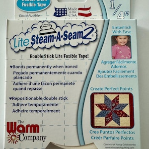 May include: A package of 1/4 inch wide, 40 yard long Lite Steam-A-Seam 2 double stick fusible tape. The package is white with red and blue accents. The text on the package reads "Lite Steam-A-Seam 2 Double Stick Lite Fusible Tape!" and "The Warm Company".
