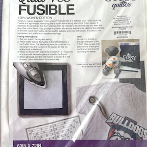 May include: A package of Quilt-Tee Fusible, a 100% woven cotton interfacing for T-shirt projects. The package includes instructions, a sample of a finished project, and a diagram. The dimensions are 60 inches by 72 inches.