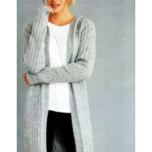 May include: A long-sleeved, light grey hooded cardigan with a vertical ribbed knit texture. The garment is open-front and hip-length. The image includes the Patons brand logo at the top and a circular graphic indicating it contains 2 patterns.