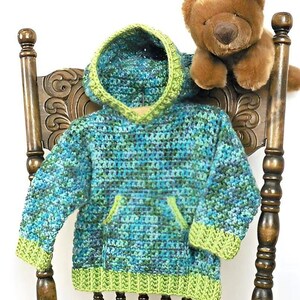 May include: A long-sleeve hooded sweatshirt made of variegated yarn in shades of blue, teal, and green. The garment features a solid lime green ribbed hem, sleeve cuffs, and hood trim, along with a front kangaroo pocket in the same lime green.