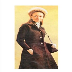 May include: A dark brown textured long coat with a button-front closure and a matching fuzzy hat. The coat features long sleeves, a structured collar, and a dark brown shoulder bag with a thin strap worn across the body over the coat.
