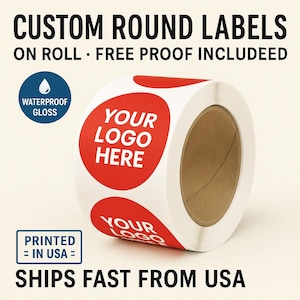 May include: A roll of custom round labels with the text "YOUR LOGO HERE" in white on a red circle. The labels are waterproof and glossy. The text "CUSTOM ROUND LABELS" and "PRINTED = IN USA =" are also visible.