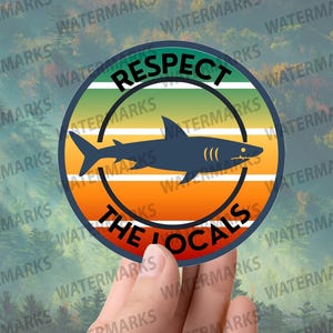 May include: A circular sticker featuring a shark silhouette against a sunset-style gradient of green, yellow, and orange. The text "RESPECT THE LOCALS" is arranged around the shark, creating a bold design.