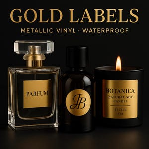 Op de afbeelding: Een parfumfles, een donkere fles met een gouden etiket en een zwarte kaars met een gouden etiket worden weergegeven tegen een zwarte achtergrond. De parfumfles heeft een gouden dop en het woord "PARFUM" op het etiket. De kaars leest "BOTANICA NATURAL SOY CANDLE BY CALM 227g."