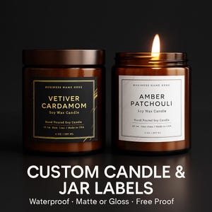 May include: Two amber glass jars with black lids containing soy wax candles. The left jar has a black label with gold text reading Vetiver Cardamom, 6 oz | 367 ml. The right jar has a white label with black text reading Amber Patchouli, 3 oz | 657 ml.