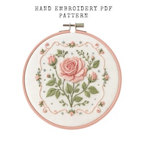May include: A hand embroidery PDF pattern showing a pink rose and buds, with green leaves and floral details. The design is set in a round, pale pink embroidery hoop. The text "HAND EMBROIDERY PDF PATTERN" is at the top of the image.