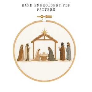 Può includere: Schema PDF per ricamo a mano con una scena della natività. Il disegno comprende figure, una stalla e una stella. Il testo "HAND EMBROIDERY PDF PATTERN" è in alto. Il ricamo è in un telaio di legno.