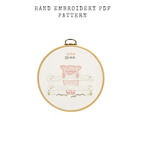 May include: Hand embroidery PDF pattern featuring a pink piglet peeking over a white fence. The word "OINK" is embroidered above the pig. The embroidery is set in a wooden hoop, with the text "HAND EMBROIDERY PDF PATTERN" above.