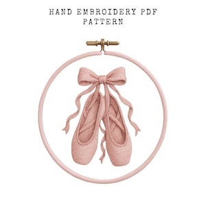 May include: A hand embroidery PDF pattern featuring a pair of pink ballet shoes with long ribbons, inside a pink embroidery hoop. The text "HAND EMBROIDERY PDF PATTERN" is at the top.