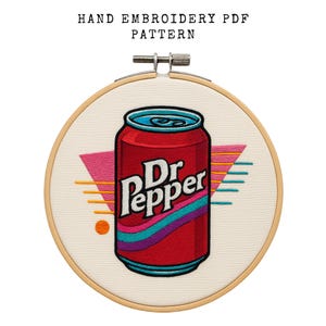 Può includere: Modello PDF di ricamo a mano con un design di lattina di Dr. Pepper rossa con accenti geometrici retrò. Il disegno è posto in un telaio da ricamo in legno. Il testo "HAND EMBROIDERY PDF PATTERN" è in alto.