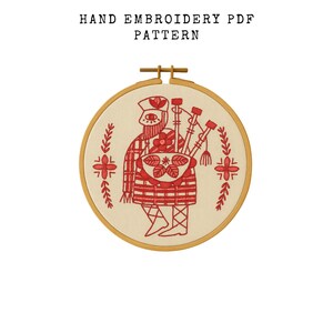 Puede incluir: Patrón PDF de bordado a mano que presenta un diseño rojo y crema de un gaitero en un bastidor de bordado de madera. El gaitero lleva un sombrero y un kilt a cuadros, sosteniendo una gaita. El texto "HAND EMBROIDERY PDF PATTERN" está en la parte superior.