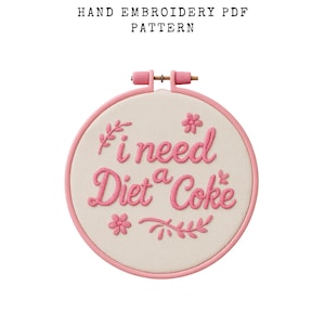 May include: A hand embroidery PDF pattern featuring a round embroidery hoop with the phrase "I need a Diet Coke" stitched in pink thread. The hoop has a light pink border and the text "HAND EMBROIDERY PDF PATTERN" is at the top.
