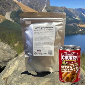 May include: A silver pouch of freeze-dried Campbell's Chunky Steak & Potatoes soup with a net weight of 1.2 ounces. The pouch is packaged in a silver foil pouch with a red and white label. The label includes instructions for reconstituting the soup and a QR code. A red and white can of Campbell's Chunky Steak & Potato soup is in the background.