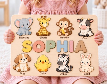 Puede incluir: Un tablero de rompecabezas de madera con el nombre SOPHIA en letras grandes y coloridas. El tablero incluye ocho figuras de animales de dibujos animados: elefante, jirafa, mono, vaca, perro, pollito, cebra y conejo, etiquetados en negro.