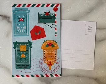 May include: A Christmas-themed postcard with a light blue background featuring illustrations of mailboxes, envelopes, and a North Pole Express Mail stamp. A blank postcard is next to it. The design includes red, green, and white accents.