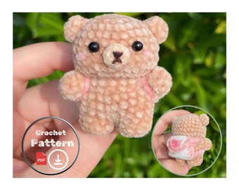 Op de afbeelding: Een haakpatroon voor een kleine, bruine teddybeer met roze accenten. Het patroon is beschikbaar als PDF-download.