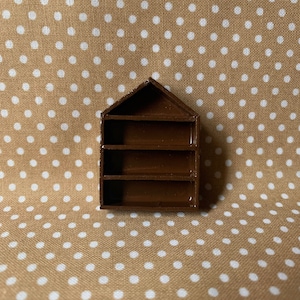 May include: A small brown wooden shelf with four shelves. The shelf is in the shape of a house.