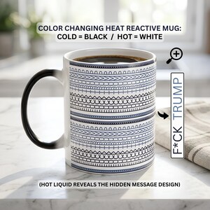 May include: A heat-reactive mug featuring a black exterior when cold that turns white when hot. The mug displays a repeating geometric pattern of horizontal lines and arches. Text on the image reads: COLOR CHANGING HEAT REACTIVE MUG: COLD = BLACK / HOT = WHITE, F*CK TRUMP, and (HOT LIQUID REVEALS THE HIDDEN MESSAGE DESIGN).