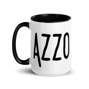 May include: White ceramic mug with a black interior and handle. The word "CAZZO" is printed in large, black, sans-serif letters on the front of the mug. The mug is designed for hot or cold beverages.