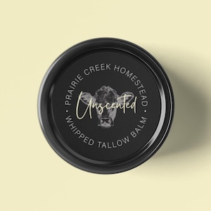 May include: A white ceramic mug with a black handle and the text "But First, Coffee" in a black, handwritten-style font. The mug is on a white surface.