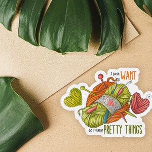 May include: A sticker with a colorful illustration of yarn balls, needles, and a heart. The text reads "I just WANT to make PRETTY THINGS".