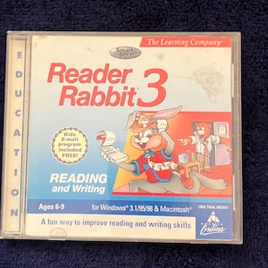 May include: A CD case for the educational computer game Reader Rabbit 3. The case is blue and white with a picture of a cartoon rabbit holding a piece of paper. The text on the case says "Reader Rabbit 3" and "Reading and Writing". The case is for ages 6-9 and is for Windows 3.1/95/98 and Macintosh.