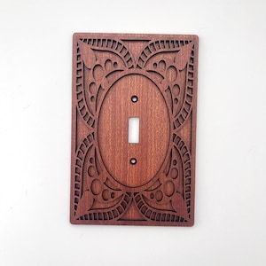 May include: A white ceramic mug with a black handle and the text "But First, Coffee" in a bold, black font. The mug is sitting on a wooden surface. The mug is approximately 4 inches tall.