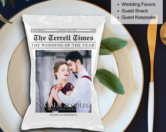May include: A white packet designed like a newspaper, "The Terrell Times," displays a photo of a couple and text. The packet is on a plate with gold trim, next to a gold and white utensil. The text reads "The Wedding of the Year!" and "Natalie & Colin Begin Their Journey."