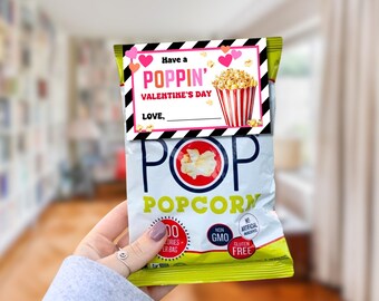 May include: A bag of popcorn with a Valentine's Day themed tag that says "Have a Poppin' Valentine's Day". The tag has pink hearts and a black and white striped background. The popcorn bag is yellow with red and blue lettering that says "POP POPCORN".