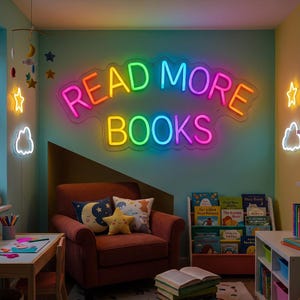 May include: A multi-colored neon sign displaying the text READ MORE BOOKS in a curved layout. The sign features glowing letters in shades of red, orange, yellow, green, blue, and pink, mounted on a clear acrylic backing against a light teal wall.