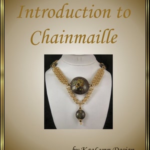 Puede incluir: Un collar de cadena de correo dorado con dos cuentas marrones, una grande y una pequeña, con diseños florales. El collar está en un expositor blanco. El texto "Introduction to Chainmaille by KaeLynn Design" está debajo de la imagen.