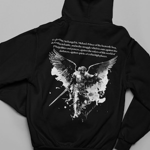 Op de afbeelding: Zwarte hoodie met een gedetailleerde zwart-witte afbeelding van aartsengel Michael. De achterkant van de hoodie bevat een citaat over aartsengel Michael. Een comfortabel en stijlvol kledingstuk.