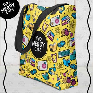 May include: Yellow tote bag with a black handle featuring a repeating pattern of books, science beakers, keyboards, and cat-themed designs. The bag has the text "Two Nerdy Cats" in a black circle.