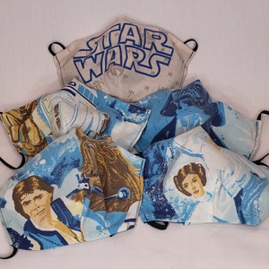 Peut inclure: Cinq masques en tissu différents avec divers personnages de Star Wars. Les masques sont bleus, blancs et bruns avec des images de Dark Vador, R2-D2, Chewbacca et la princesse Leia.