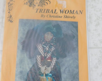 May include: A sewing pattern for a tribal woman doll. The pattern is titled "Tribal Woman" by Christine Shively. The doll is wearing a colorful dress and a basket.