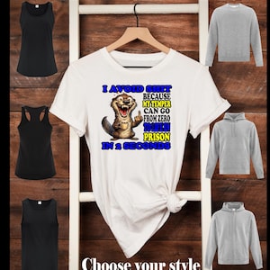 May include: A white short-sleeved t-shirt featuring a graphic of an otter holding a coffee cup and giving the middle finger, with the text: I AVOID SHIT BECAUSE MY TEMPER CAN GO FROM ZERO TO LIFE IN PRISON IN 2 SECONDS. Includes black tank tops and grey sweatshirts.