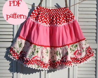 May include: A PDF pattern for a multi-layered skirt with red polka dots, pink fabric, and a floral print. The skirt has a white lace trim and is hanging on a clothesline.